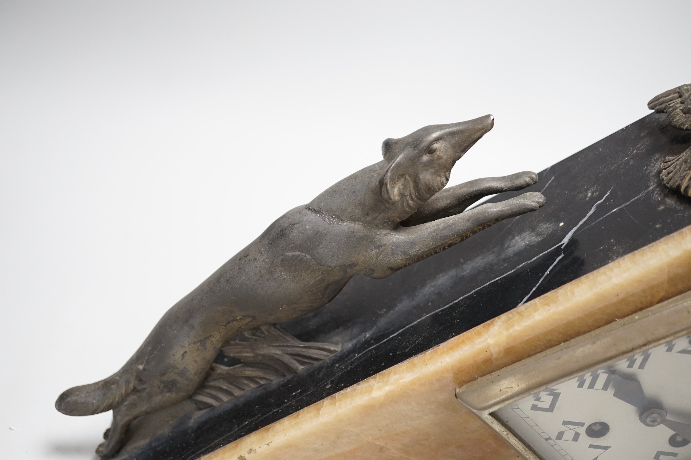 An Art Deco triangular marble and spelter clock, mounted with a fox chasing a bird, 39cms wide